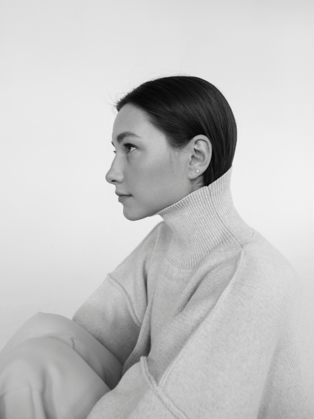 woman looking up in white turtleneck sweater